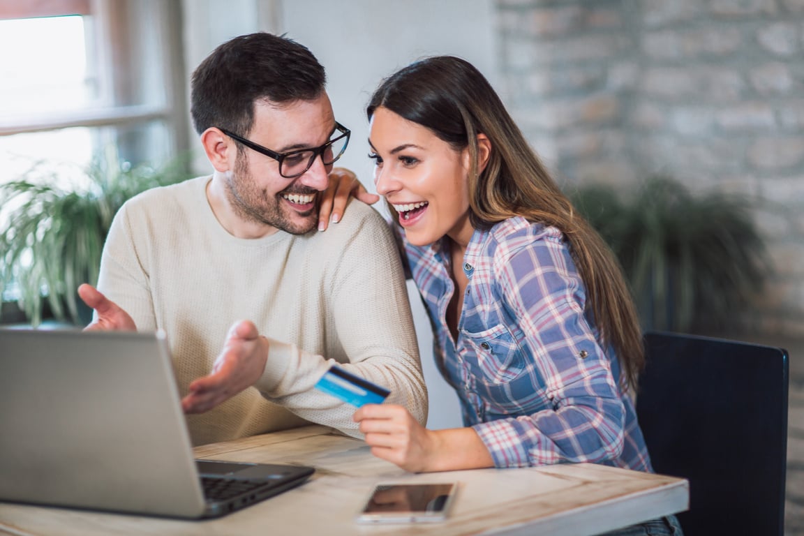 Young couple with Laptop Computer and Credit Card buying online